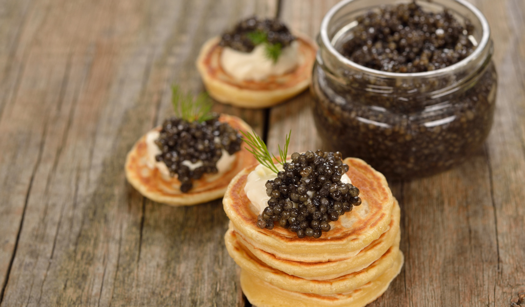 Pancakes with caviar and greens on the table