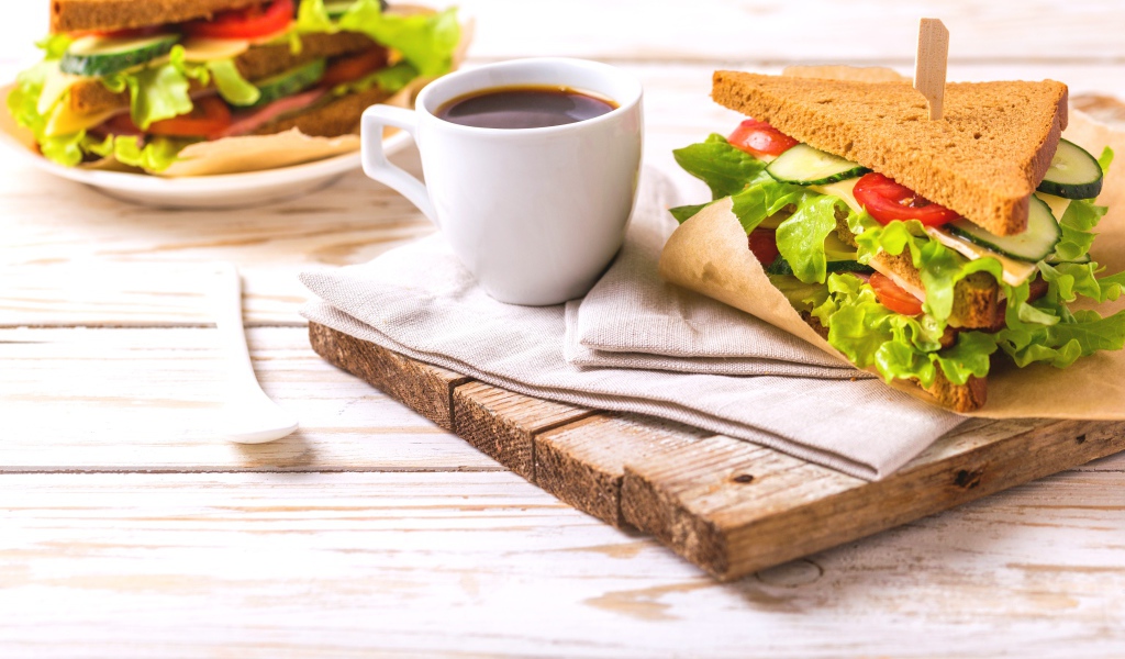 Сэндвич на столе с чашкой кофе на завтрак