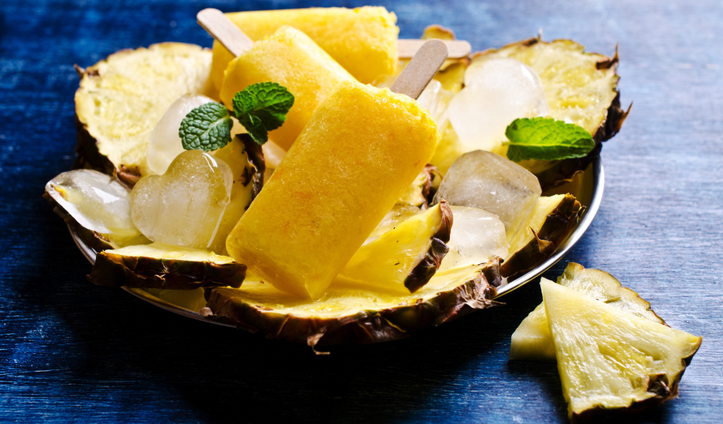 Ананасовое мороженое со льдом лежит на кусочках свежего ананаса