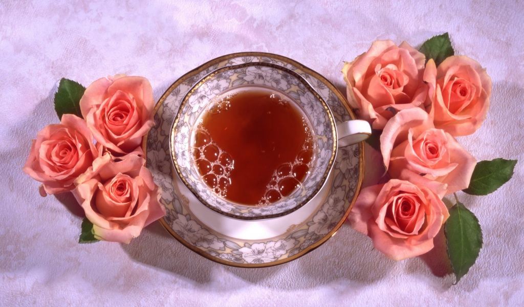 Красивая чашка черного чая на столе с розовыми розами