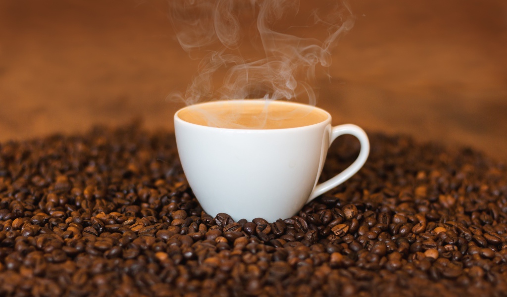 Белая чашка с кофе на кофейных зернах
