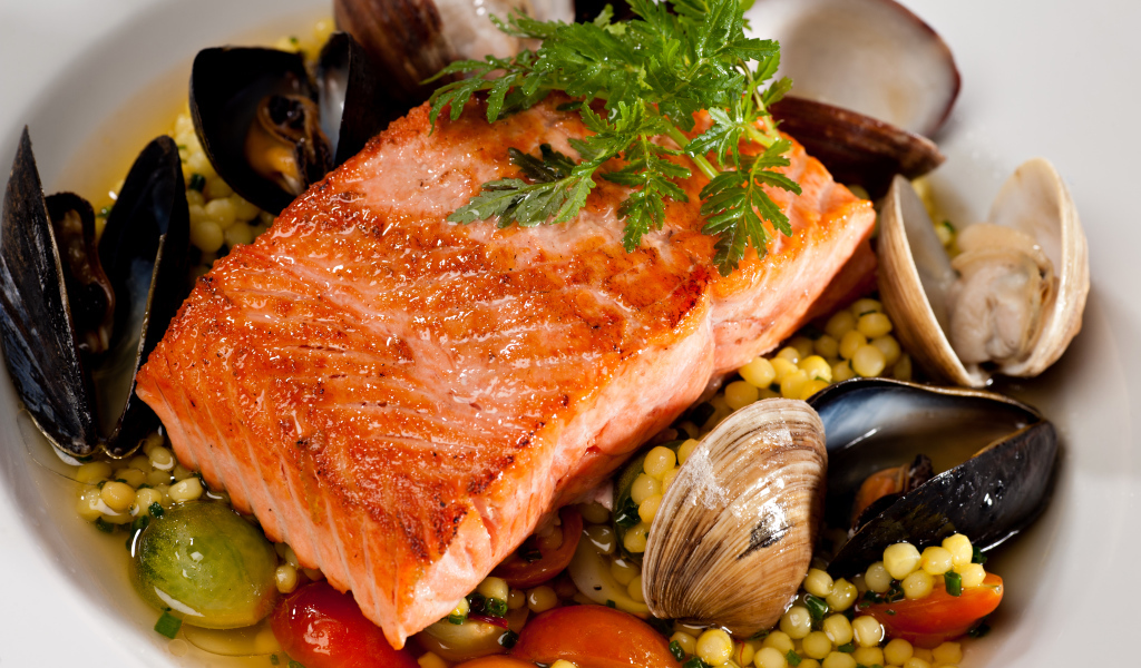Кусок красной рыбы с морепродуктами и овощами 