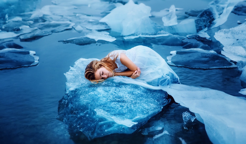 Девушка в красивом белом платье лежит на льдине