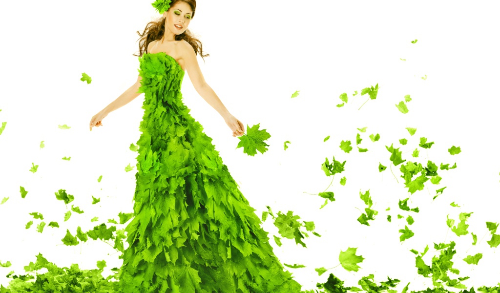 Красивая молодая девушка в платье из зеленых листьев на белом фоне