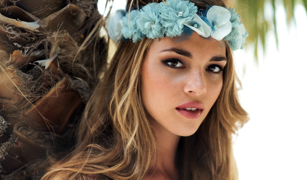Молодая девушка модель с венком из голубых цветов на голове 