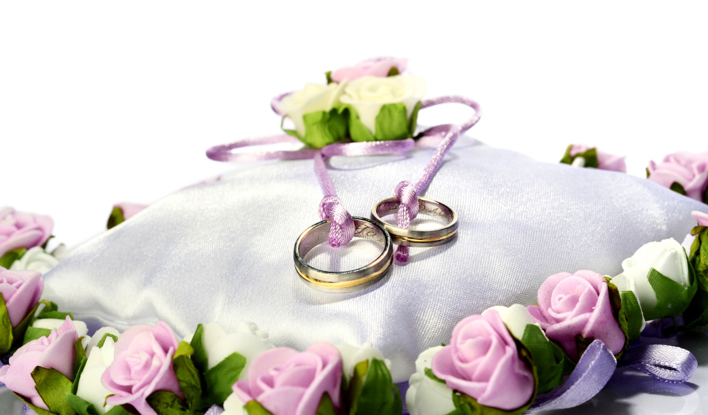 Два золотых обручальных кольца на подушечке на свадьбу