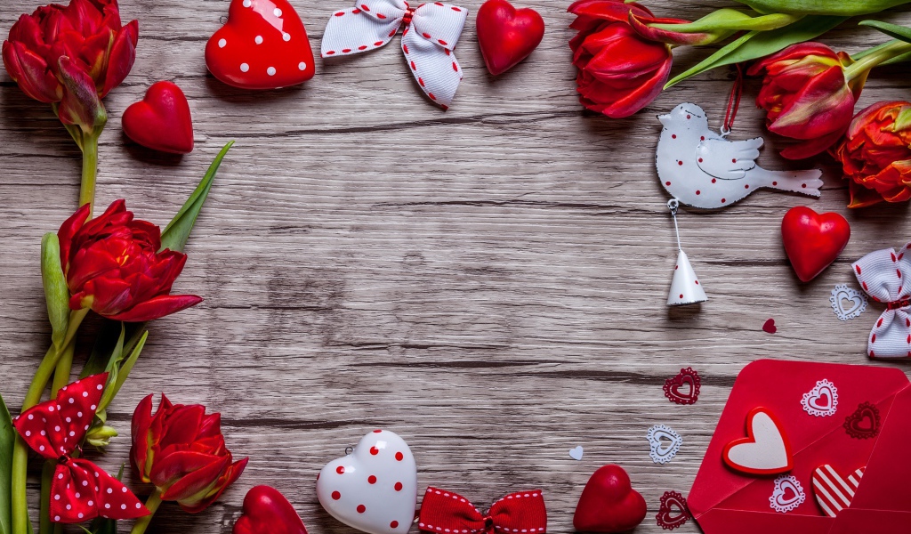 Красные тюльпаны с сердечками и бантиками на деревянной поверхности