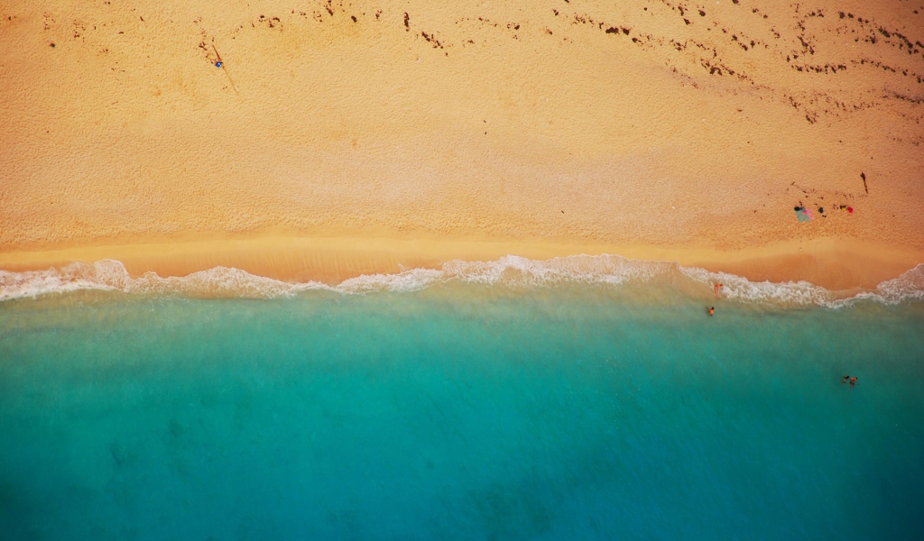 Желтый песок соединяется с голубой водой 