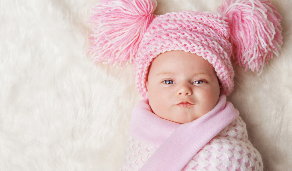 Милая малышка в красивой розовой шапке 