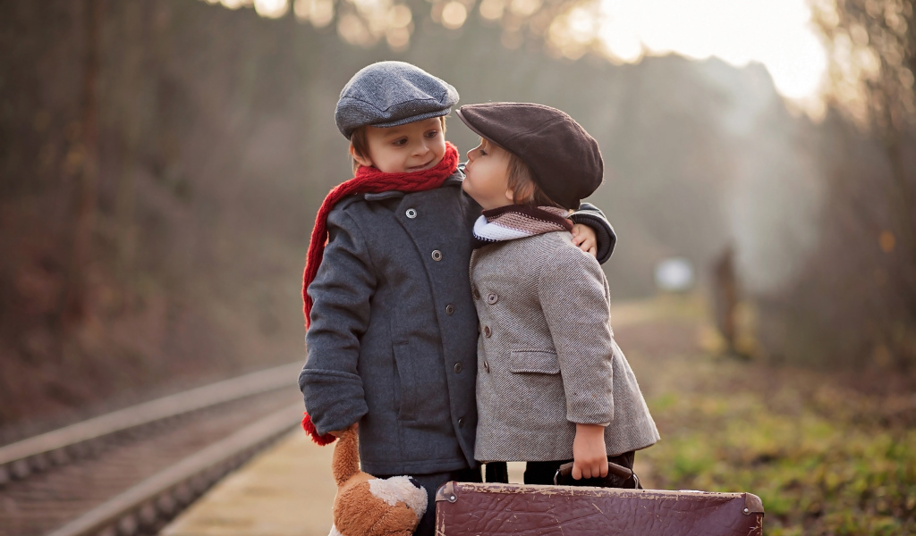 Два мальчика с большим чемоданом у железной дороги