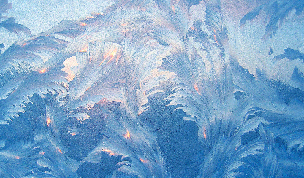 Красивые голубые морозные узоры на стекле