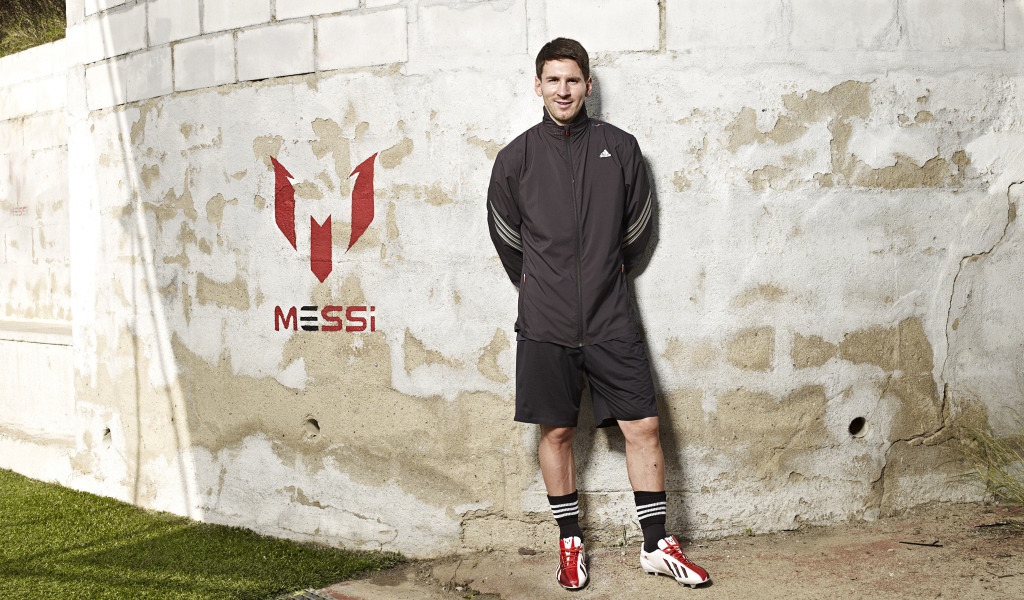 Footballer Lionel Messi poses on the wall background