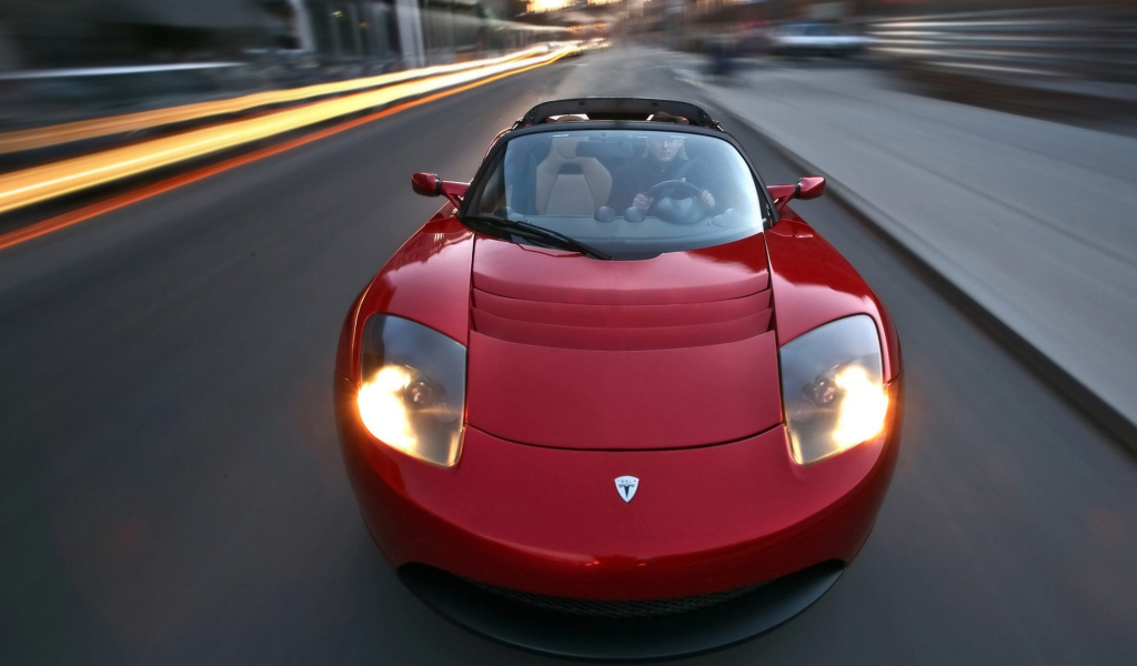 Red electric Tesla Roadster on the road