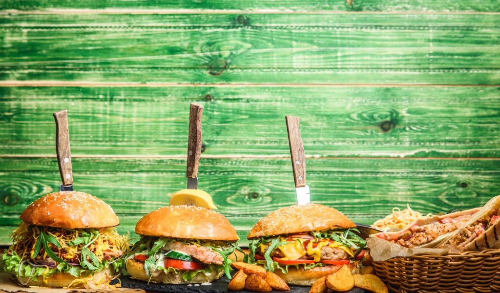 Гамбургеры с ножами на деревянном фоне