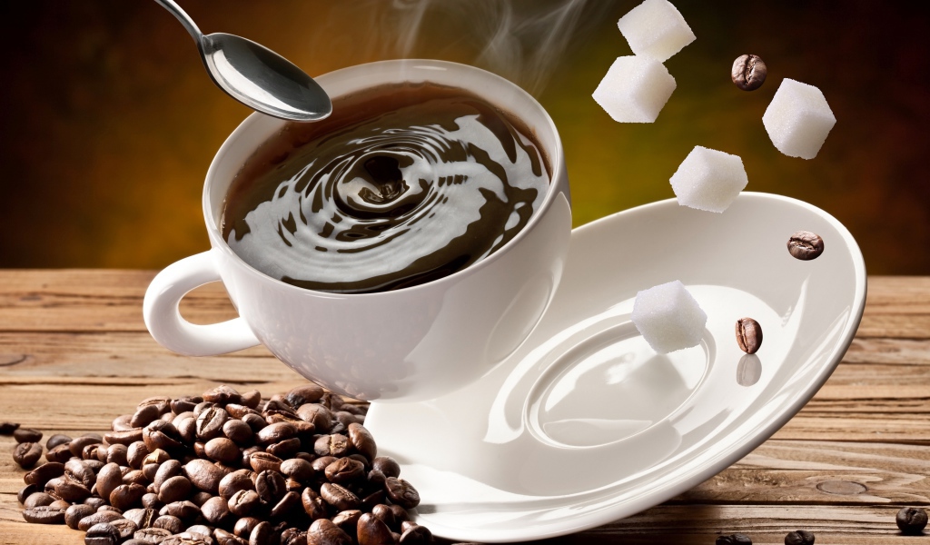 Белая чашка с кофе падает на стол с кофейными зернами