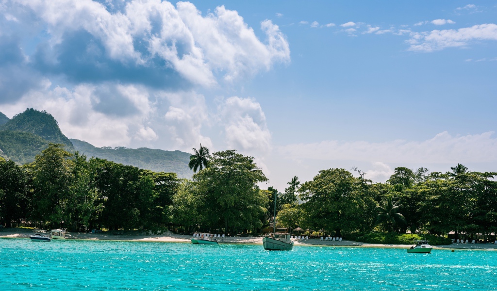Лодки у берега острова Маэ на Сейшельских островах под красивым небом