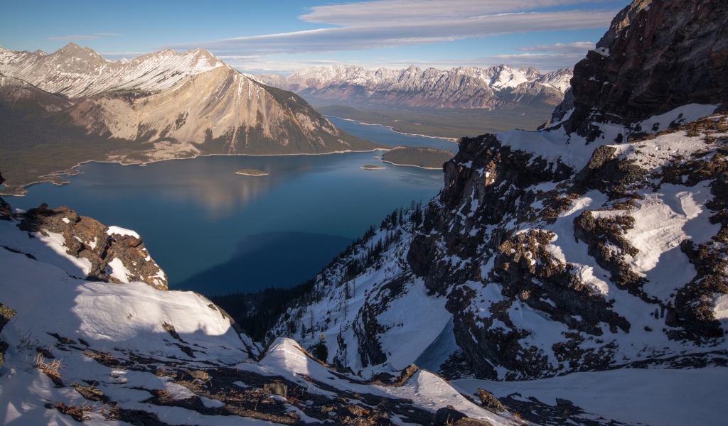 Озеро между заснеженных гор на фоне голубого неба