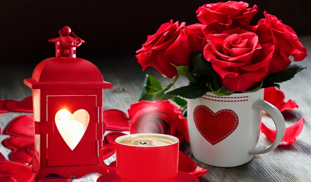 Букет красных роз в чашке на столе с фонариком и чашкой кофе