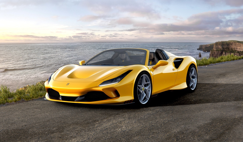 Желтый кабриолет Ferrari F8 Spider 2019 года у океана