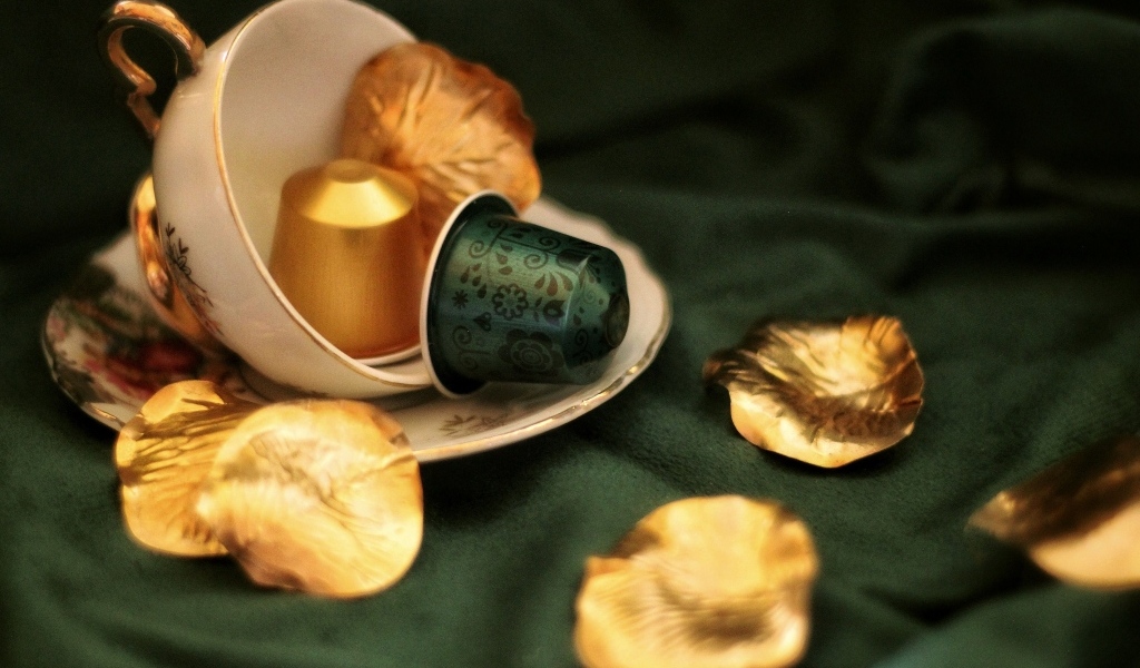Золотые лепестки и чашка на столе