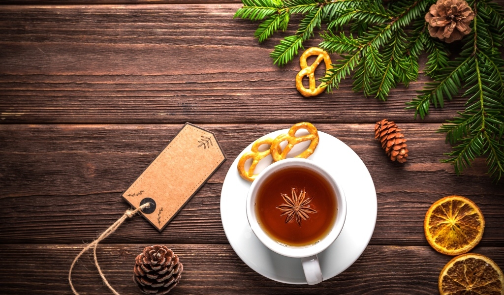Чашка ароматного чая с веткой ели на деревянном фоне 