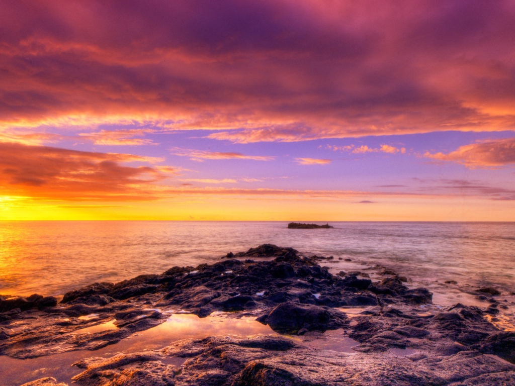 Разноцветный закат на каменистом побережье