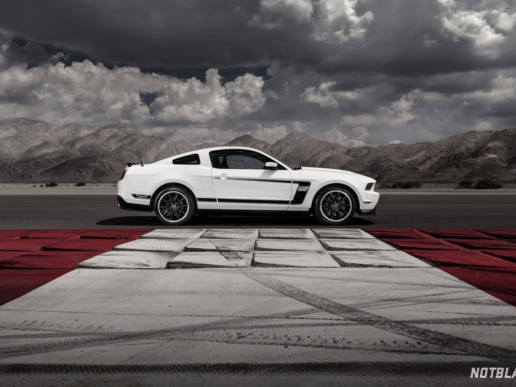 Белый Ford Mustang на фоне гор и облаков