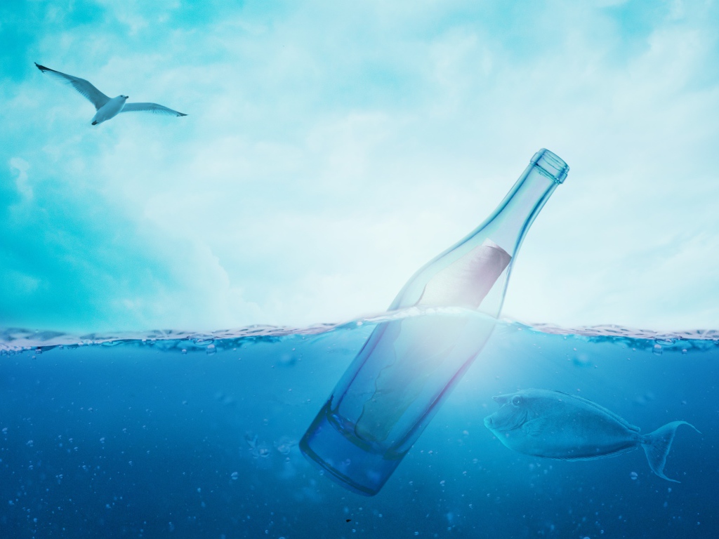 Бутылка с запиской в океана с рыбами под голубым небом