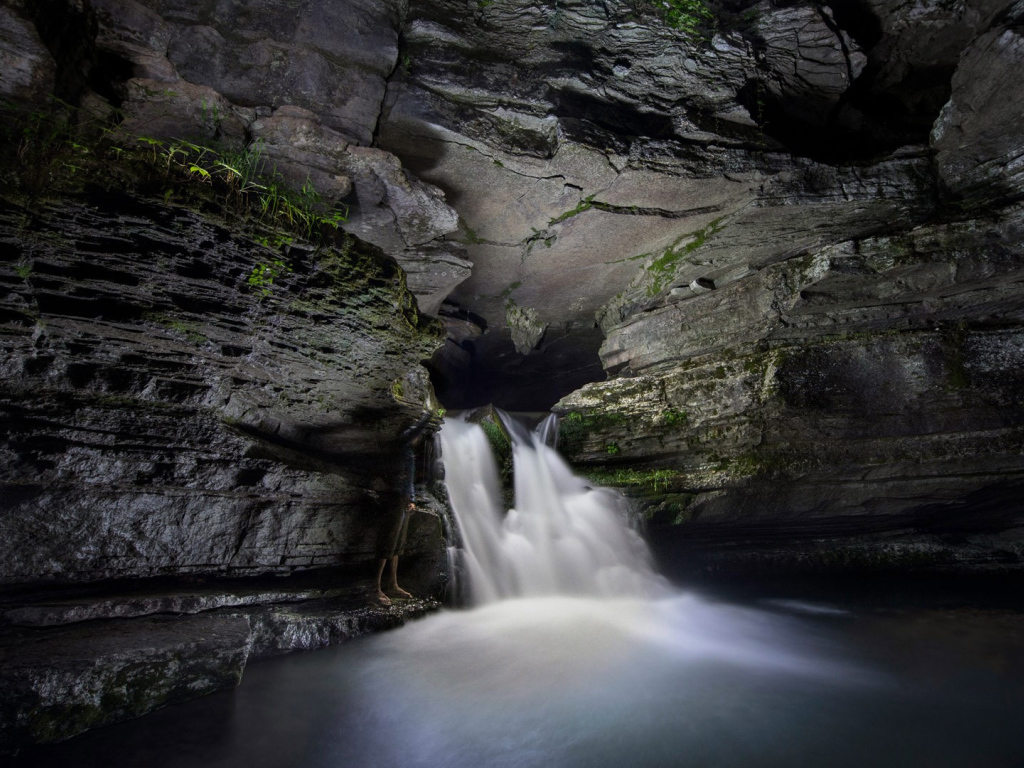 Быстрый водопад в каменной пещере 