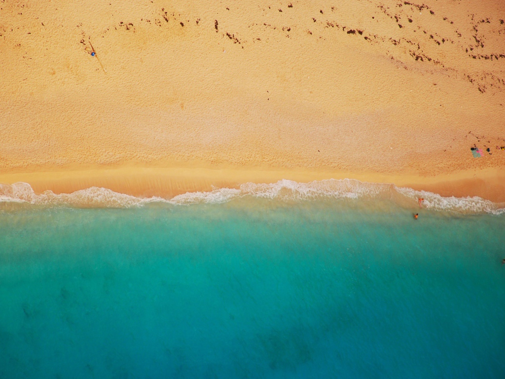 Желтый песок соединяется с голубой водой 
