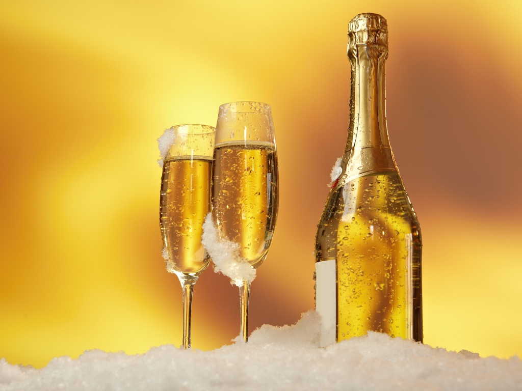 Бутылка шампанского и два фужера стоят на белом снегу