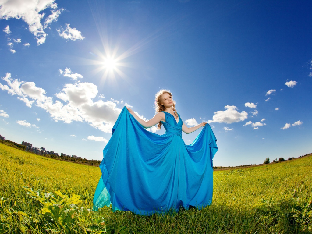 Девушка в красивом голубом платье на фоне неба