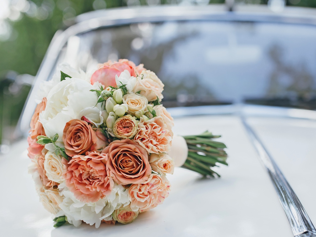 Свадебный букет роз лежит на машине