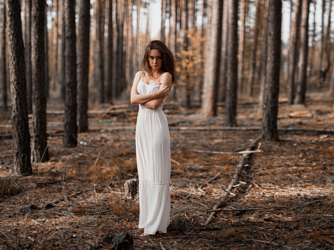 Молодая девушка в белом платье в лесу 