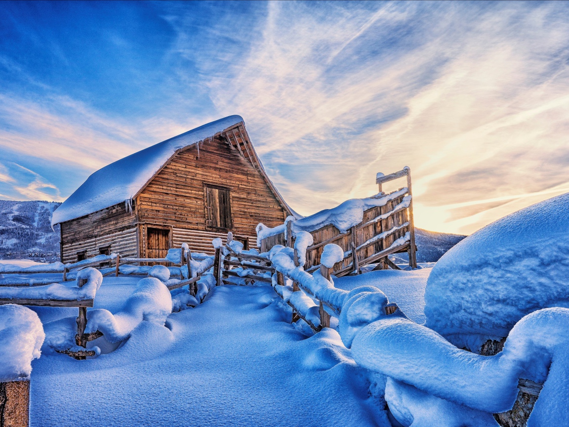 Покрытый снегом дом в горах под красивым небом