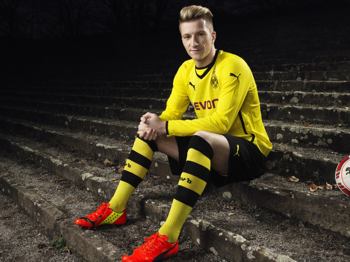 Немецкий футболист Марко Ройс сидит на ступеньках 