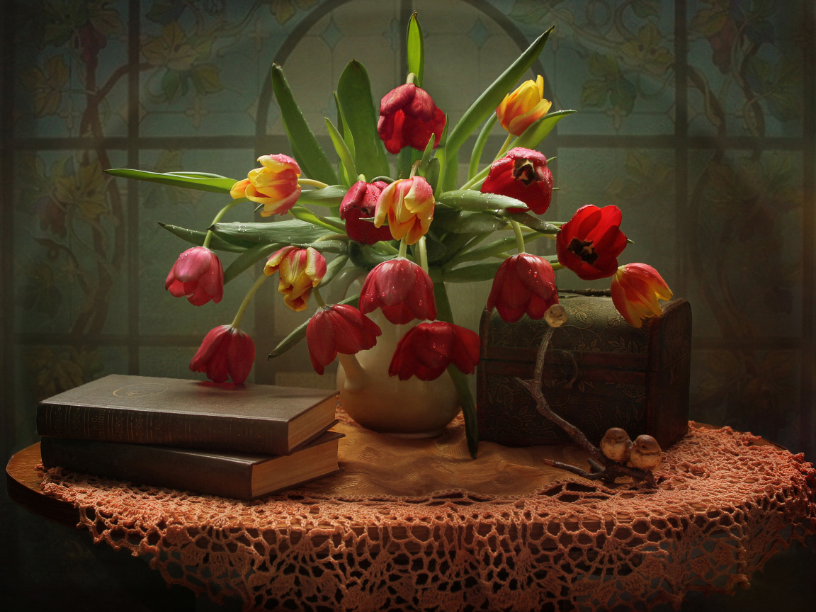 Букет тюльпанов на столе с книгами и шкатулкой