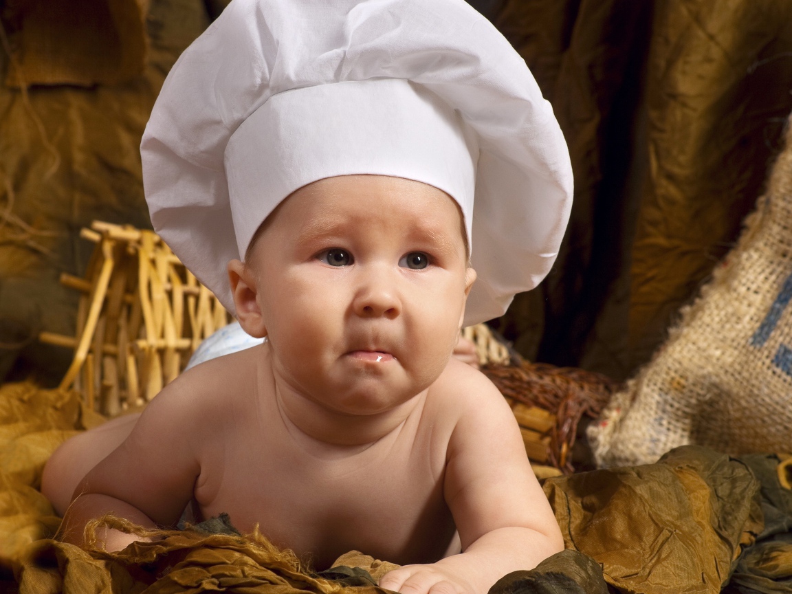 A baby in a white chef's hat