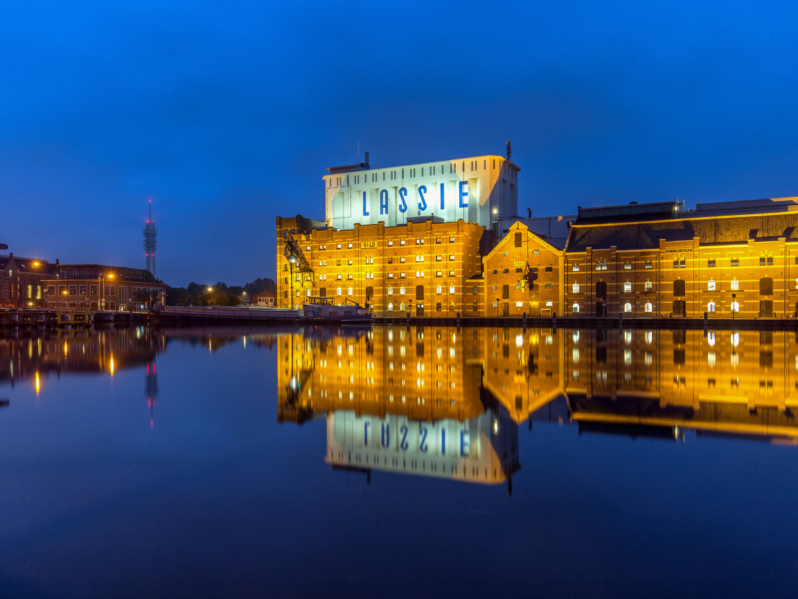 Здание завода у воды ночью, Нидерланды