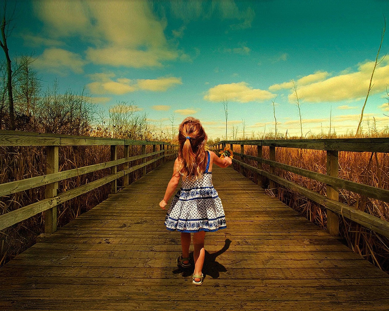 Девочка идет по деревянному мосту