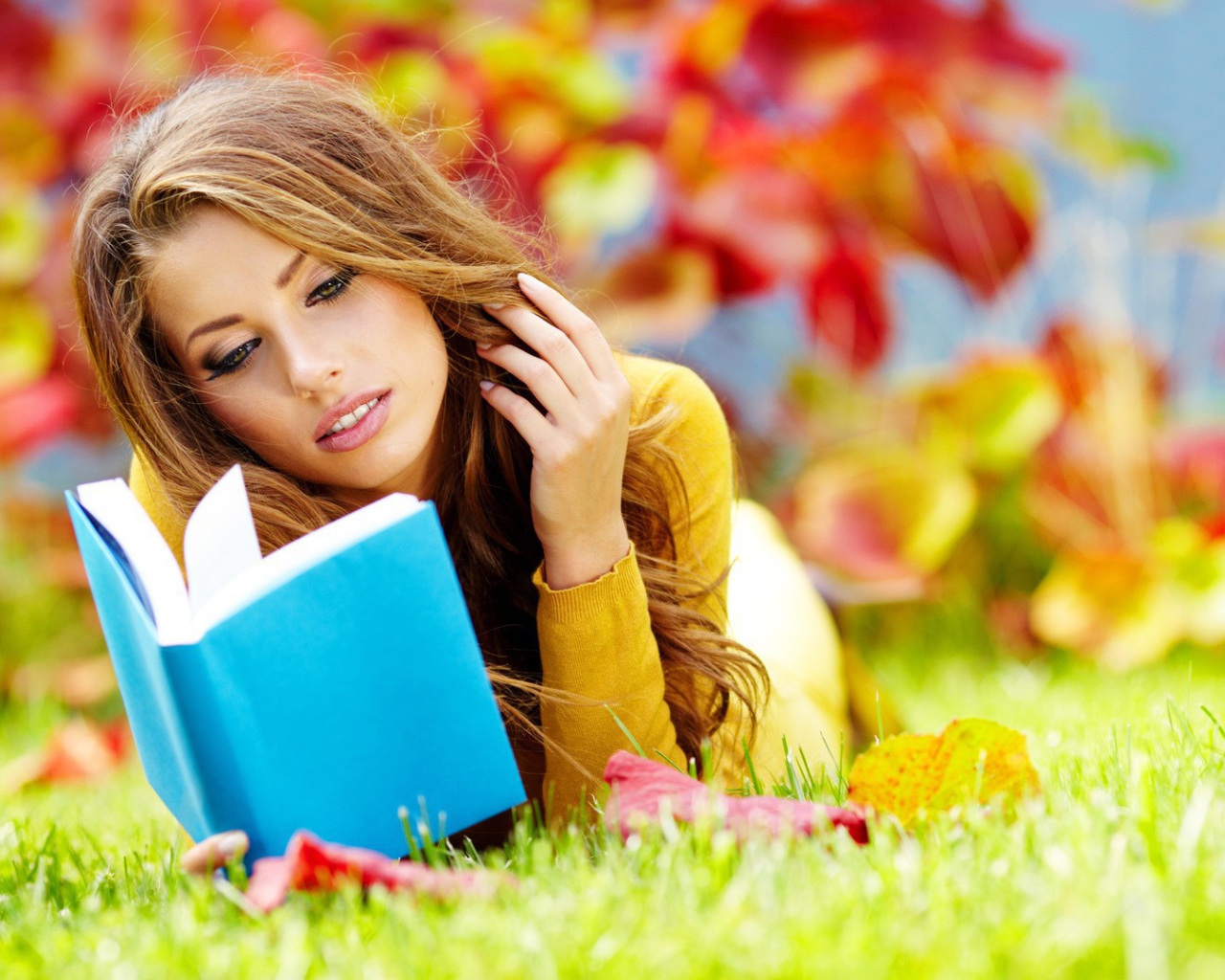 Девушка на траве читает книгу