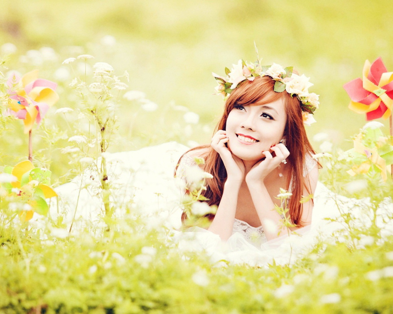 Рыжая японская девушка лежит в поле цветов