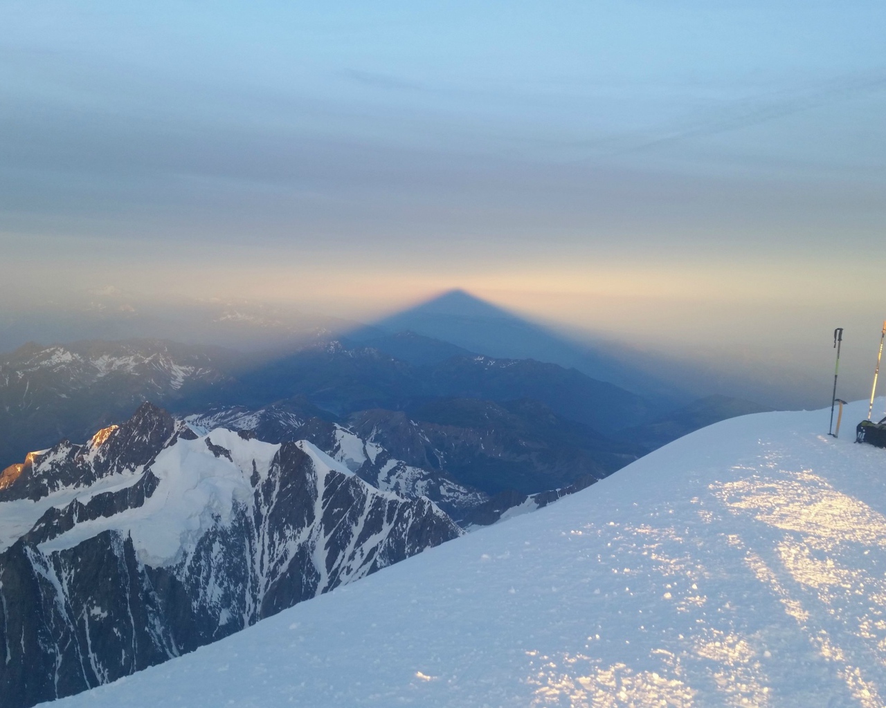 Лыжники на вершине горы перед закатом солнца