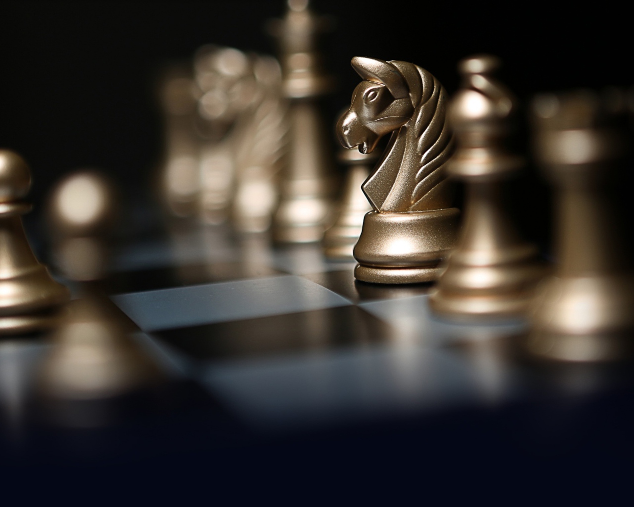 Золотые шахматные фигуры на шахматной доске