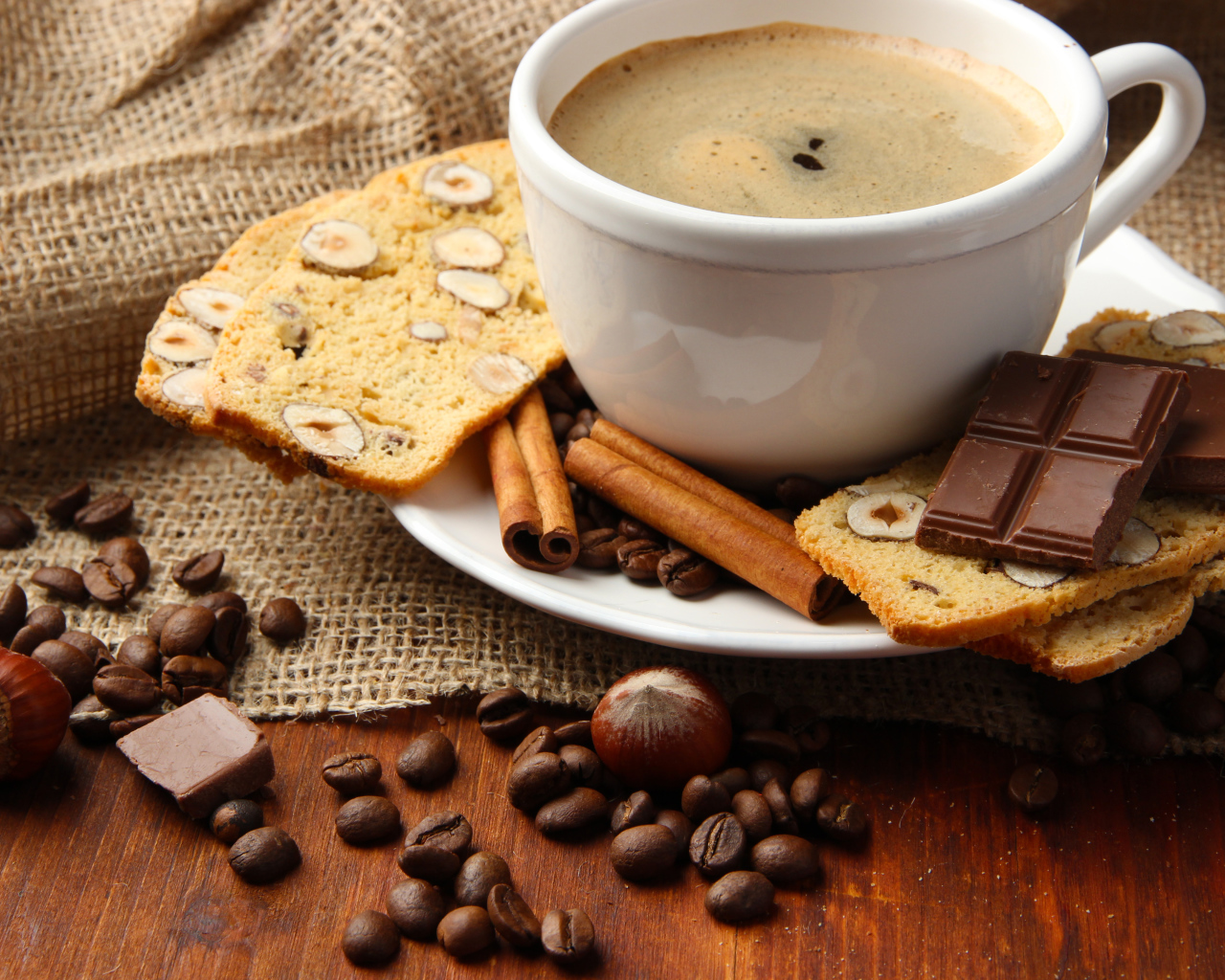 Чашка кофе с выпечкой, кофейными зернами и шоколадом