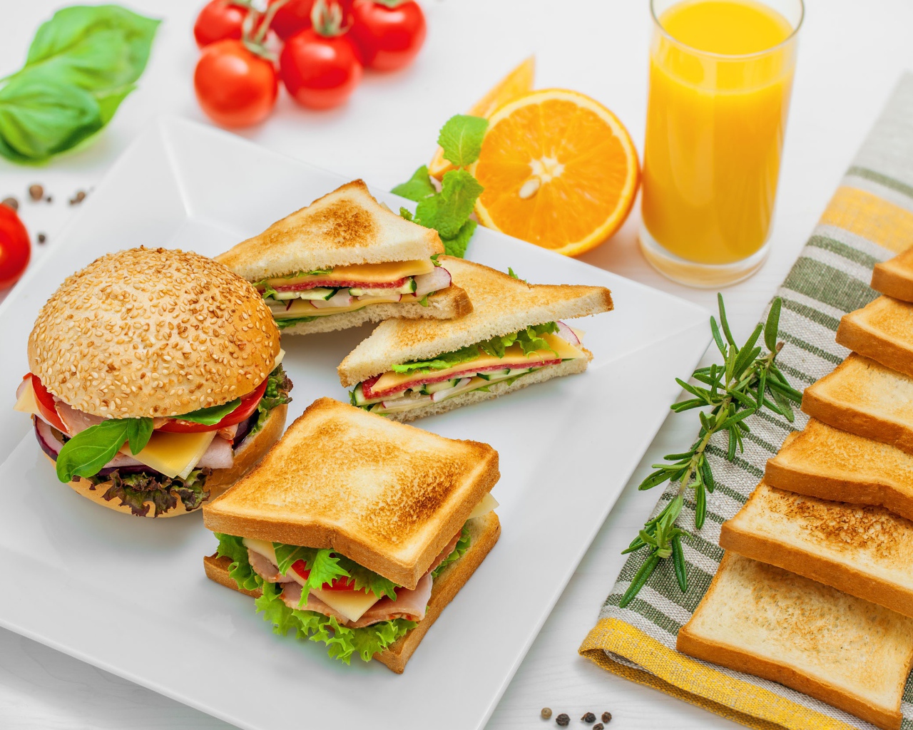 Гамбургер и сендвичи на столе с апельсиновым соком