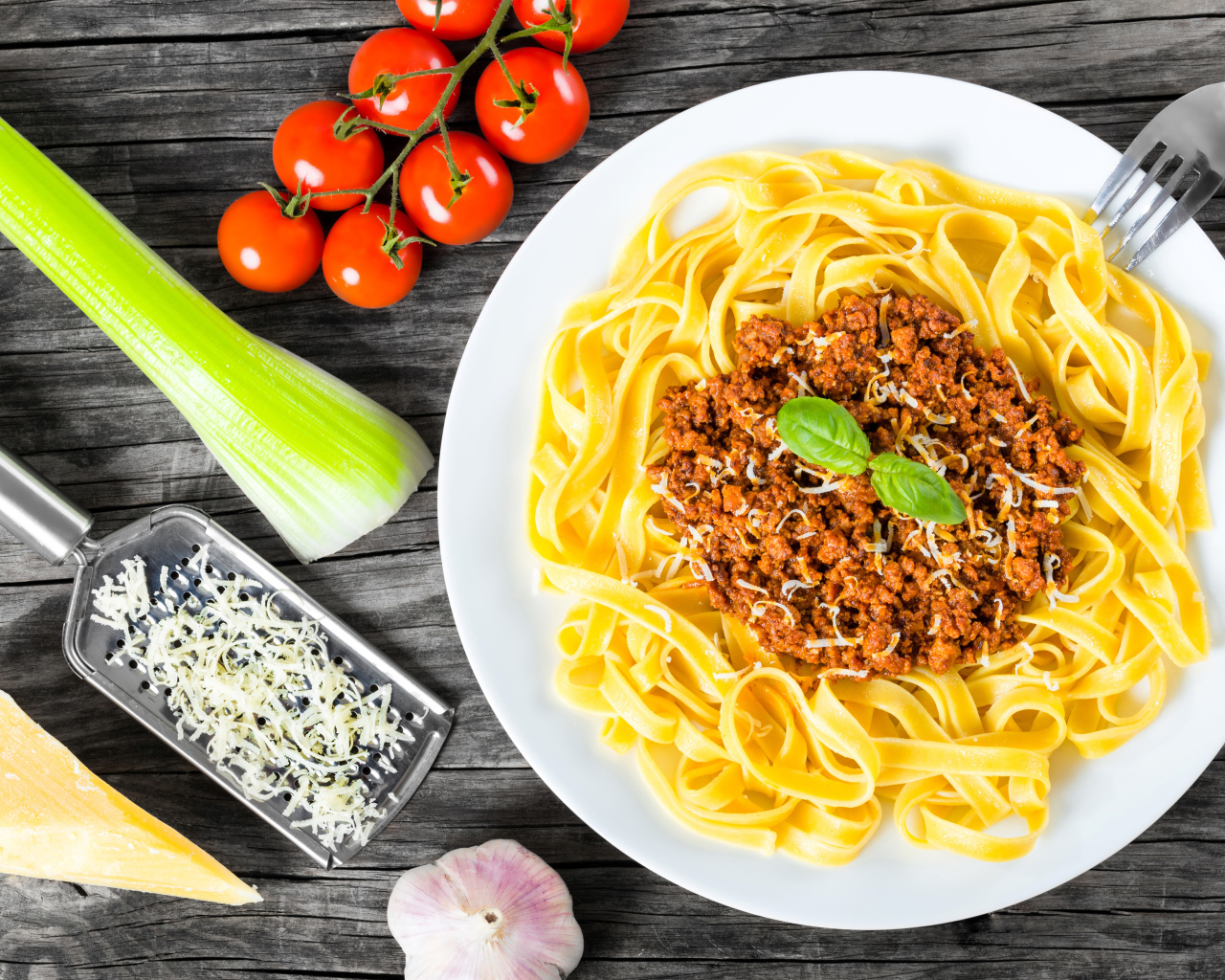 Спагетти на белой тарелке с мясом и сыром