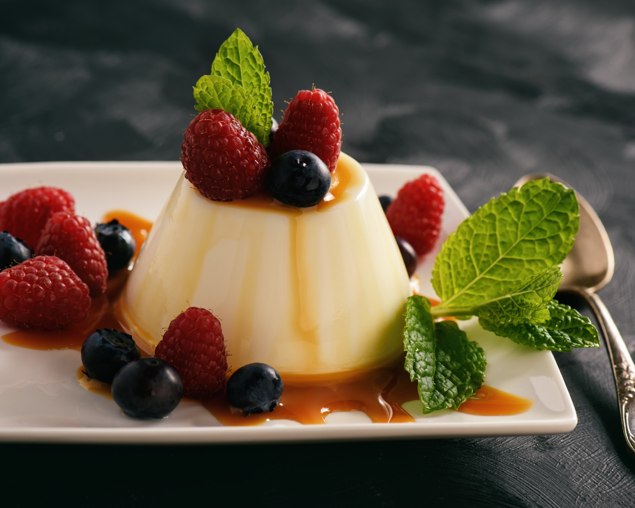 Аппетитный десерт с ягодами клубники и черники на белой тарелке