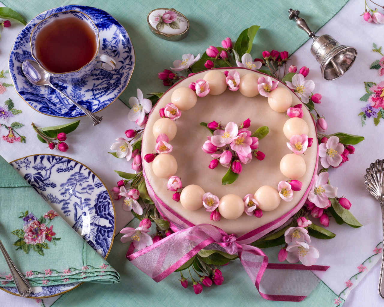 Торт с розовыми цветами на столе с красивым сервизом 