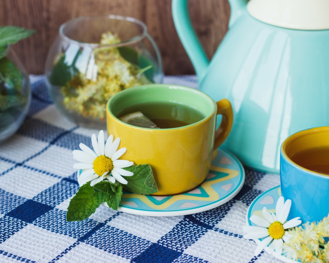 Чай с цветами ромашки в желтой чашке на столе